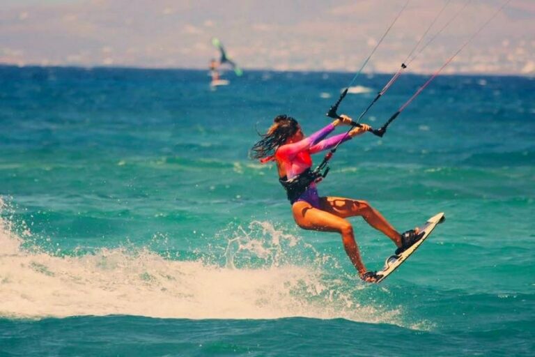 A girl is kitesurfing in Plaka Beach