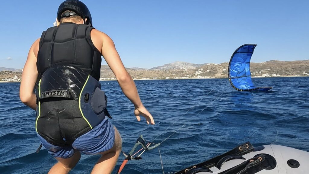 A student getting ready to jump into the water to start his kitesurfing lesson in Naxos