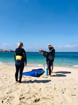 student is pumping the kite so they can strat their kitesurfing lesson in naxos.